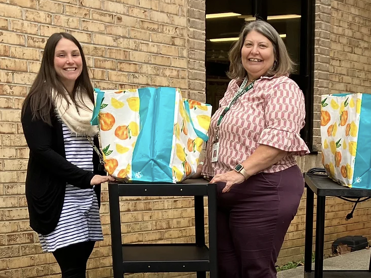 Two teachers posing with gift bags from the FHF Fund